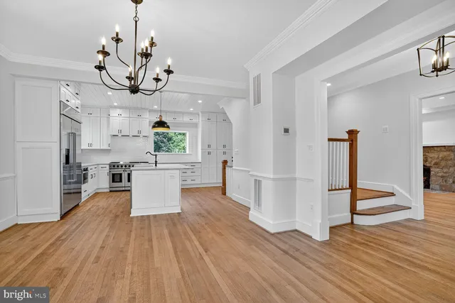 a view of a room with wooden floor and chandelier