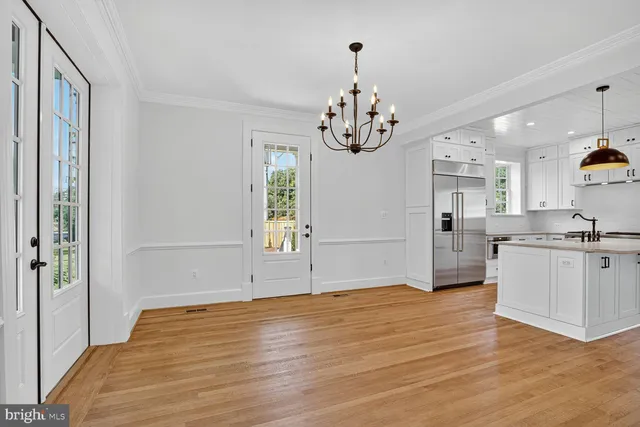 a view of a kitchen with kitchen island stainless steel appliances wooden floor and window