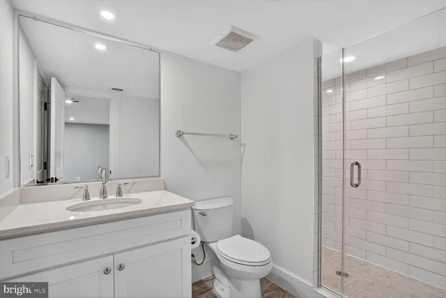 a bathroom with a granite countertop sink a toilet and shower