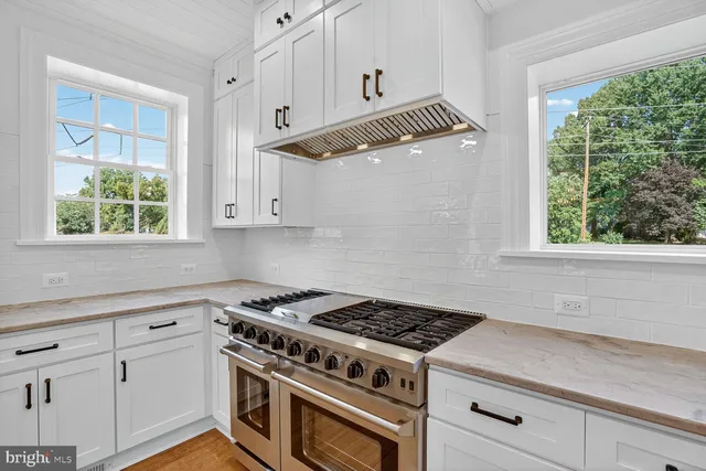 a kitchen with white cabinets and a stove top oven