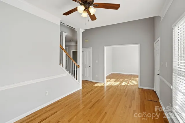 a view of a livingroom with wooden floor and a ceiling fan