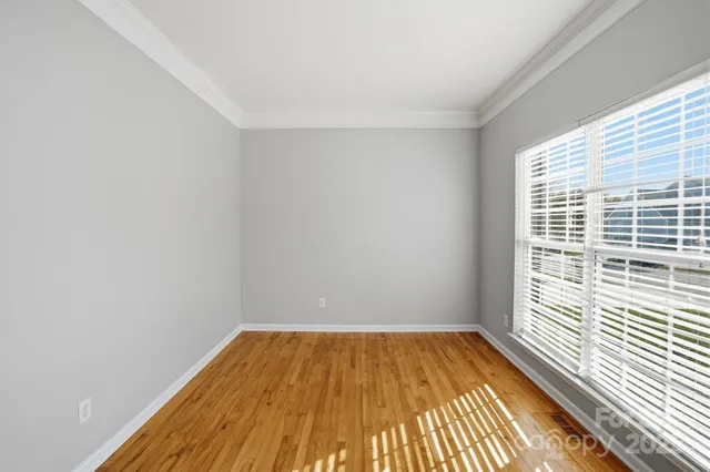 a view of a room with wooden floor and a window