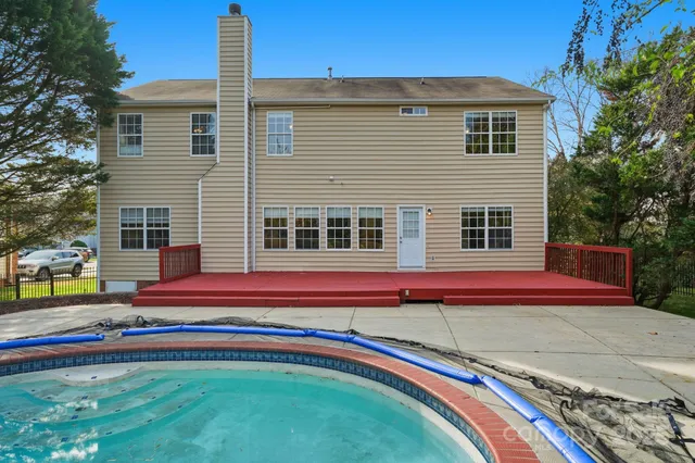 a swimming pool with outdoor space and trees in the background