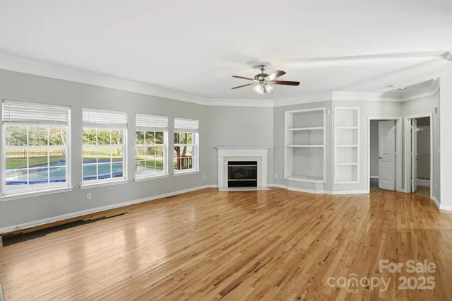 a view of an empty room with a fireplace and a window