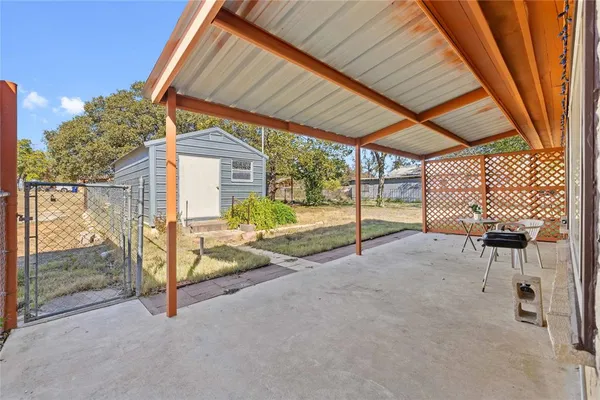 a view of backyard with wooden fence and a couple of lawn chairs