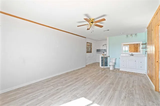 a view of a livingroom with wooden floor and a ceiling fan
