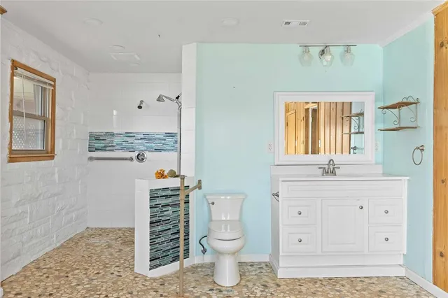 a bathroom with a toilet a sink a vanity and window
