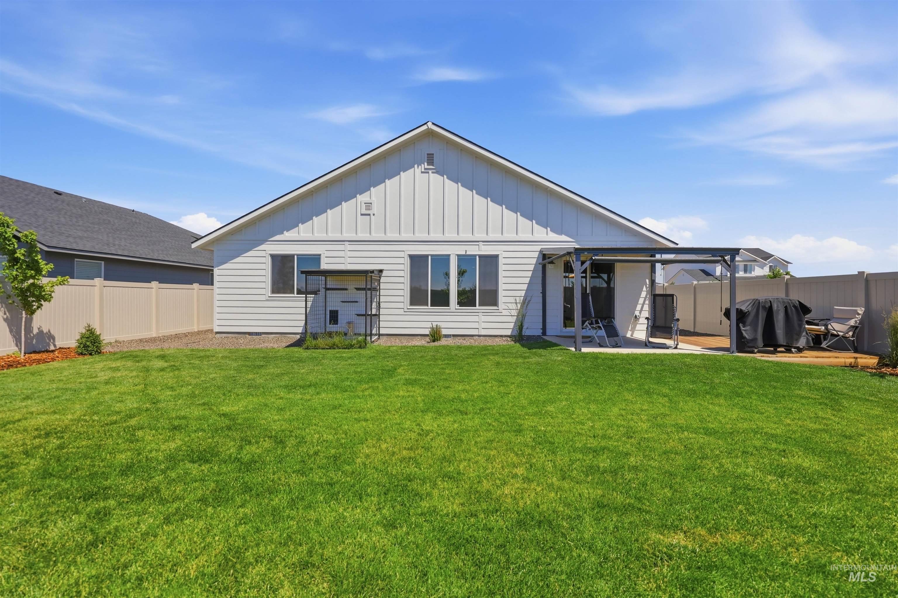 3811 West Maypearl Street Meridian, ID 83642 - Photo 33 of 39 Expansive backyard featuring a lush lawn, a white board and batten exterior, a covered patio, and a light-colored privacy fence