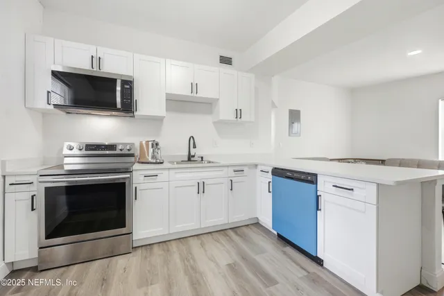 a kitchen with cabinets stainless steel appliances and a sink