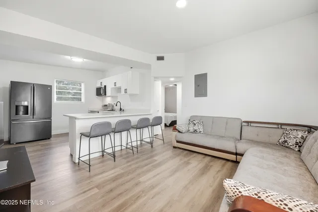 a living room with furniture and a wooden floor