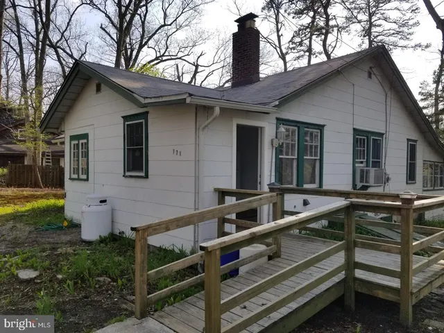 a view of house with backyard and sitting area