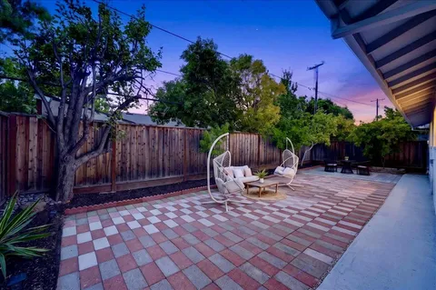 a backyard of a house with table and chairs