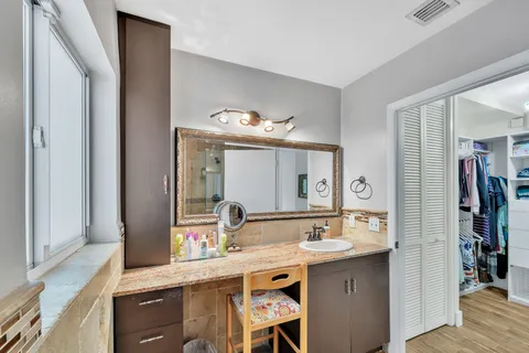 a view of a hallway with wooden floor and closet area