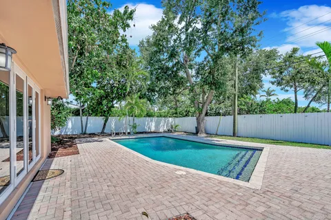 a view of backyard with swimming pool and seating space