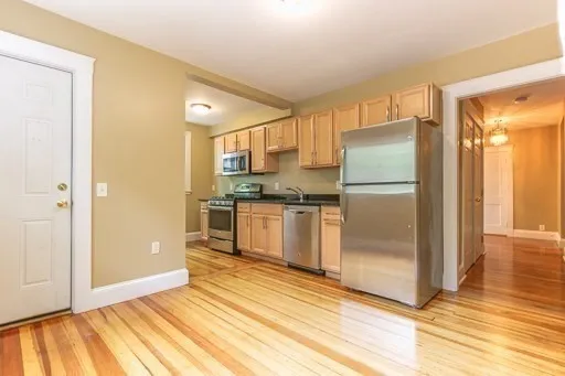 a kitchen with a refrigerator a microwave and cabinets