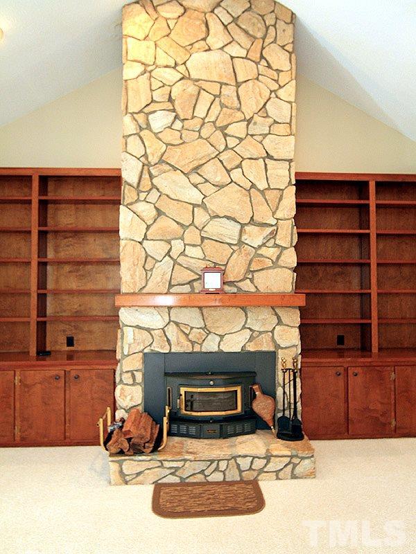 4117 Lassiter Road Wake Forest, NC 27587 - Photo 3 of 22 The floor to ceiling stone fireplace flanked by built-ins makes this large family room feel warm and inviting.