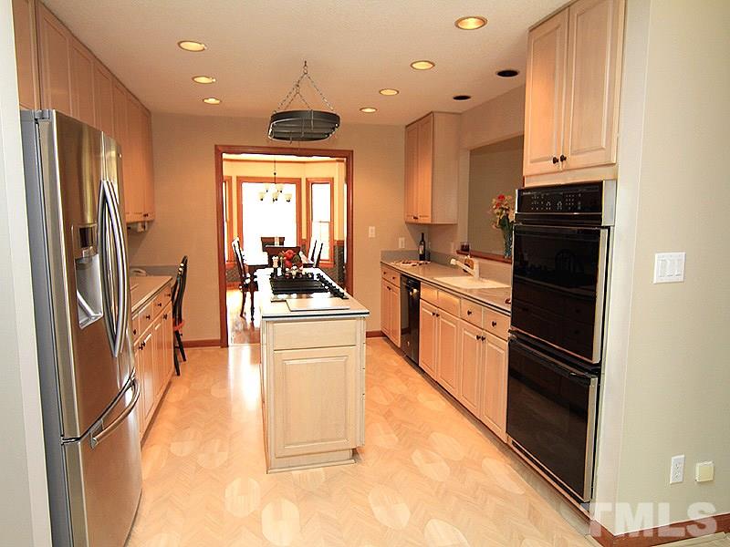 4117 Lassiter Road Wake Forest, NC 27587 - Photo 5 of 22 Cooking will be a dream in this open kitchen with cook top center island, hanging pot rack and solid surface counter tops!
