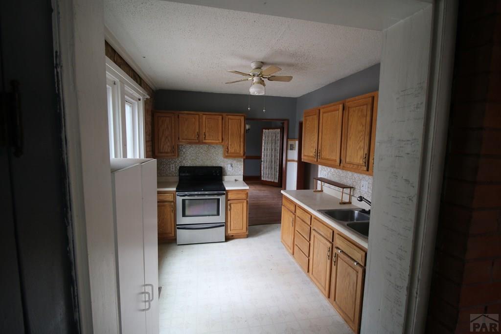 604 South Main Street Fowler, CO 81039 - Photo 8 of 38 a kitchen with a stove sink and a refrigerator