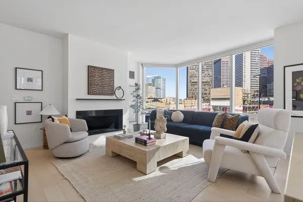 a living room with furniture fireplace and a large window