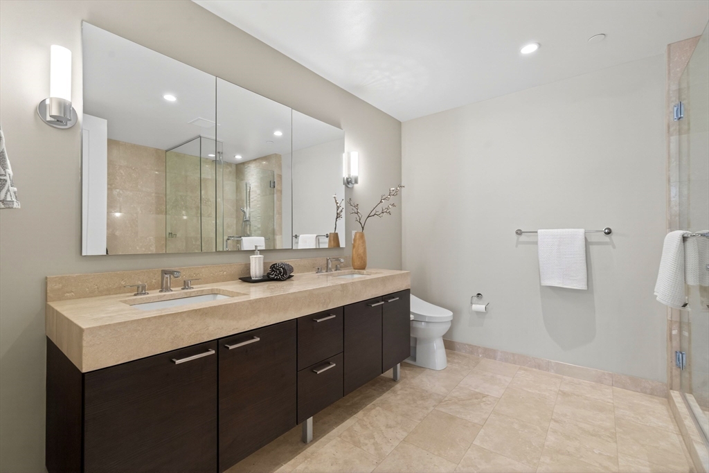 1 Franklin Street, Unit 1408 Boston, MA 02110 - Photo 15 of 37 a bathroom with a double vanity sink mirror and toilet