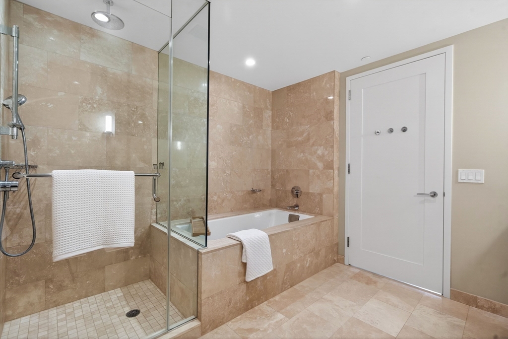 1 Franklin Street, Unit 1408 Boston, MA 02110 - Photo 16 of 37 a bathroom with a tub shower sink and mirror