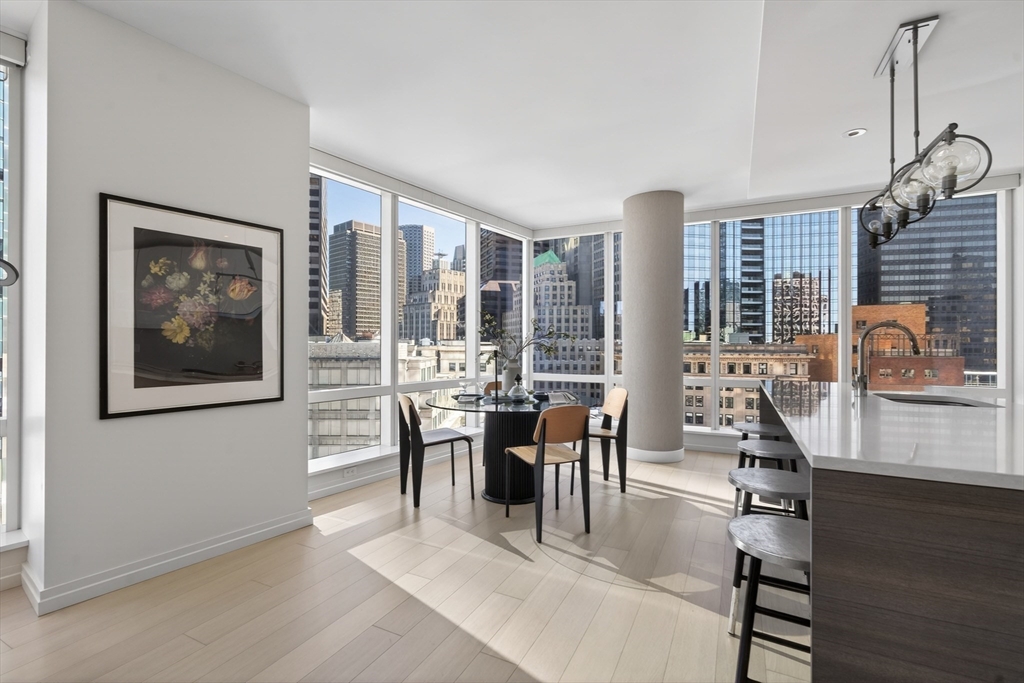 1 Franklin Street, Unit 1408 Boston, MA 02110 - Photo 4 of 37 a dining room with wooden floor and large windows