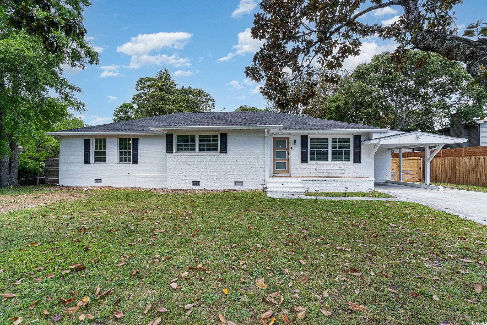 Ranch-style home featuring crawl space, brick siding, concrete driveway, a carport, and roof with shingles