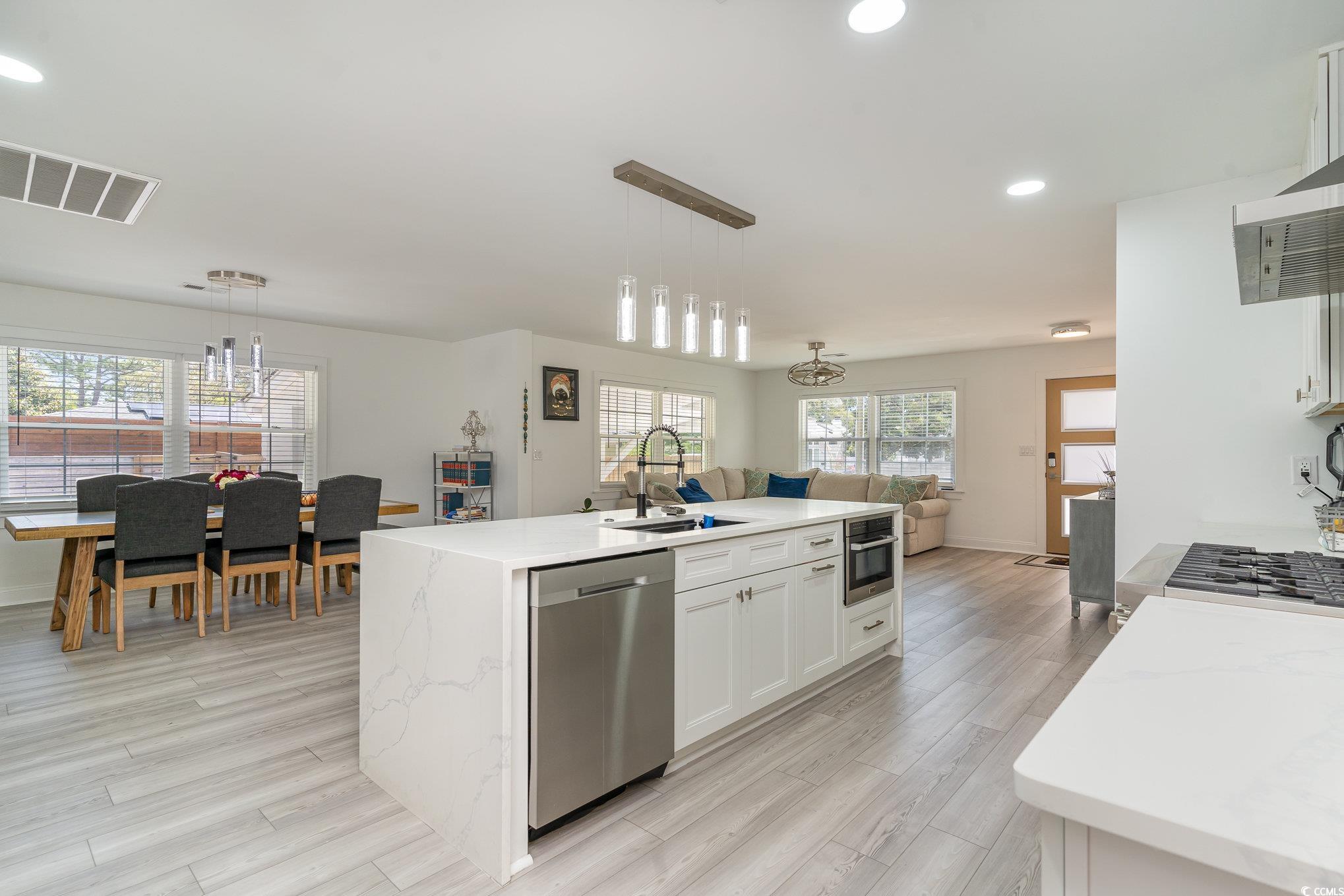 5811 Sumter Drive Myrtle Beach, SC 29577 - Photo 39 of 39 Kitchen featuring open floor plan, recessed lighting, pendant lighting, stainless steel appliances, and white cabinets