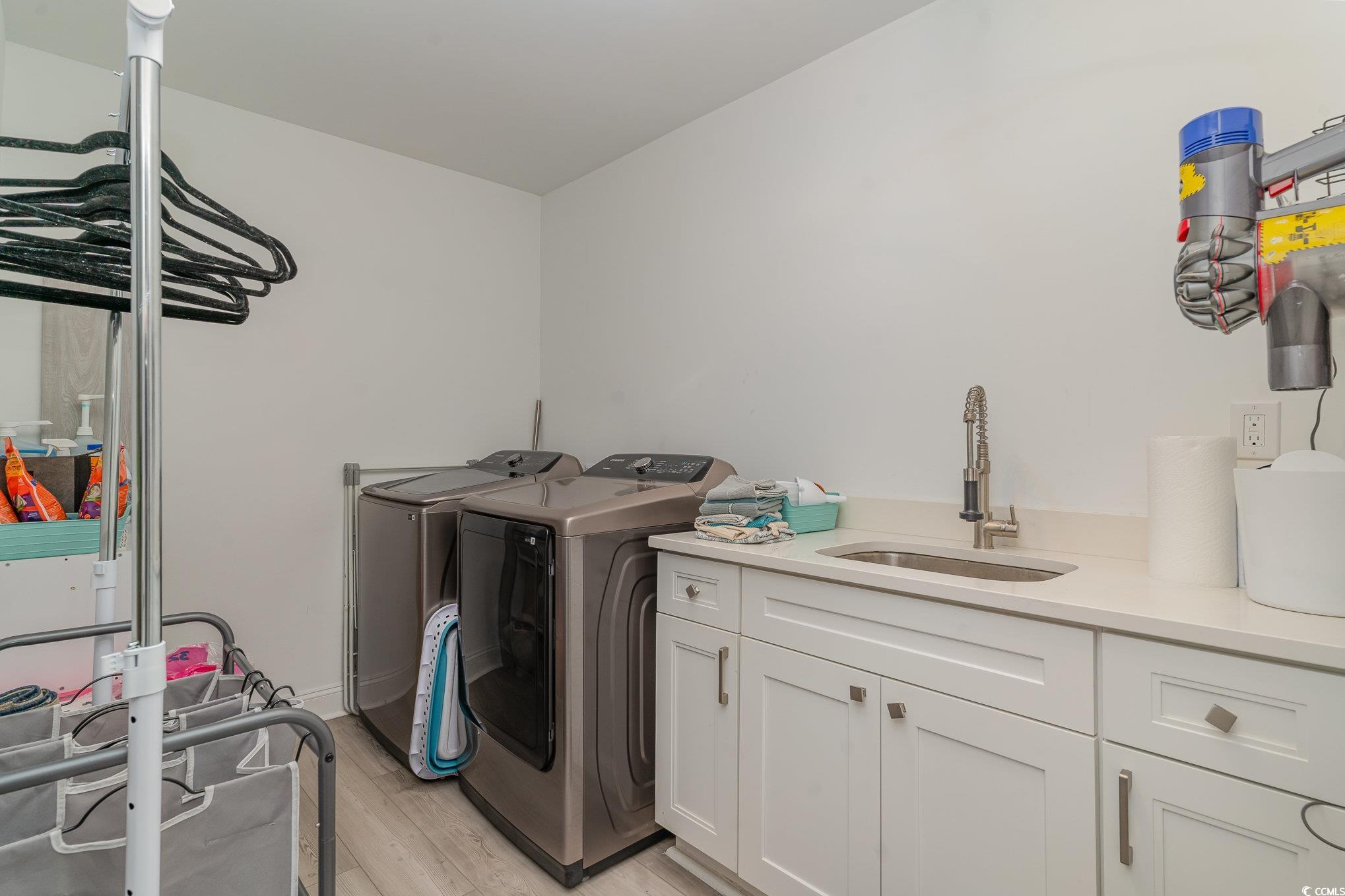5811 Sumter Drive Myrtle Beach, SC 29577 - Photo 16 of 39 Laundry area with light wood-style flooring, separate washer and dryer, and cabinet space