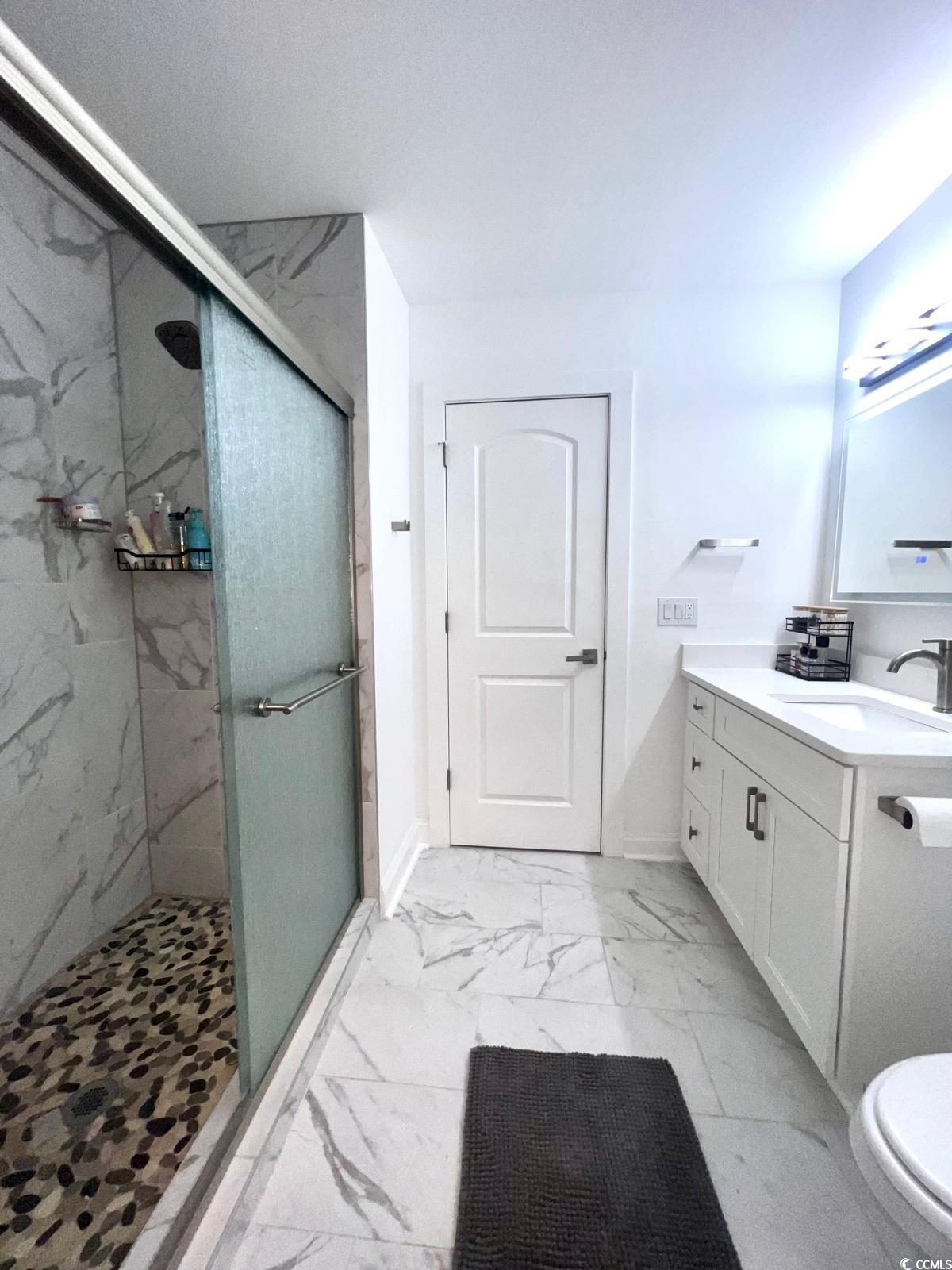 5811 Sumter Drive Myrtle Beach, SC 29577 - Photo 19 of 39 Bathroom with a marble finish shower, vanity, and light marble finish flooring