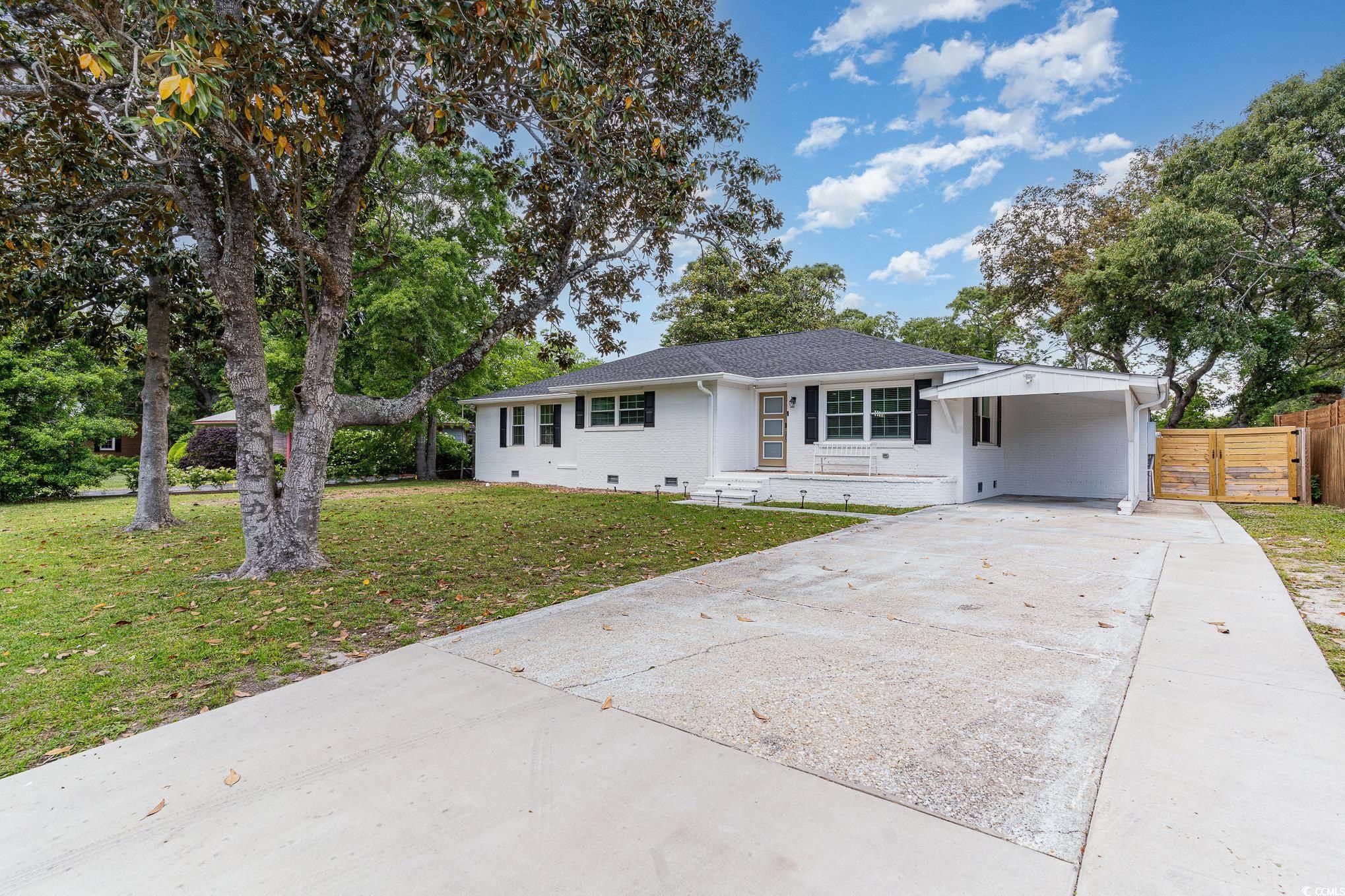 5811 Sumter Drive Myrtle Beach, SC 29577 - Photo 2 of 39 Ranch-style house with concrete driveway, brick siding, a front yard, an attached carport, and crawl space