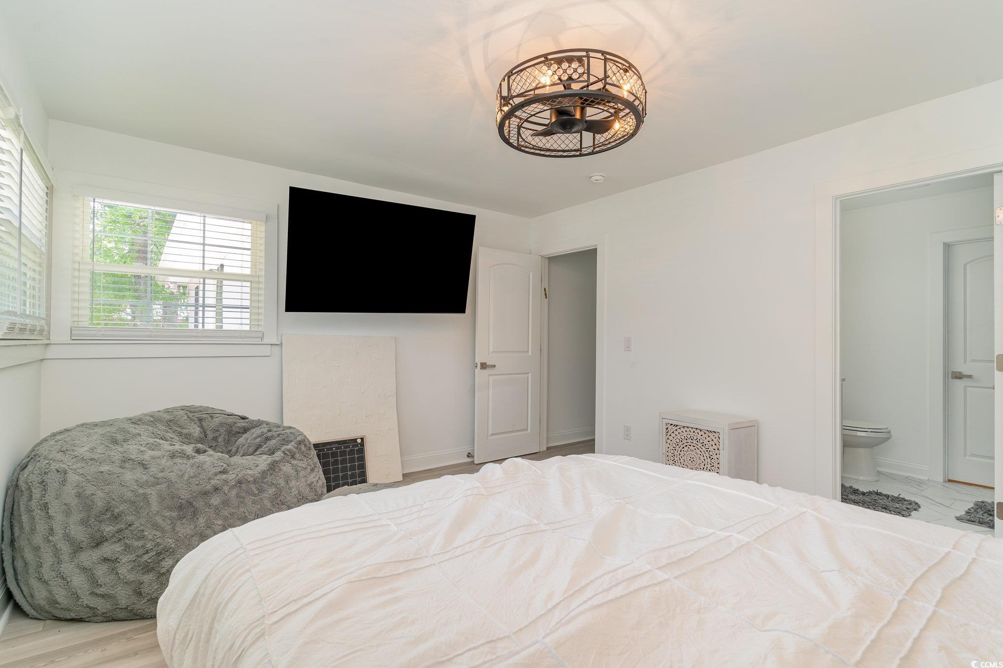 5811 Sumter Drive Myrtle Beach, SC 29577 - Photo 20 of 39 Bedroom featuring wood finished floors and ensuite bath