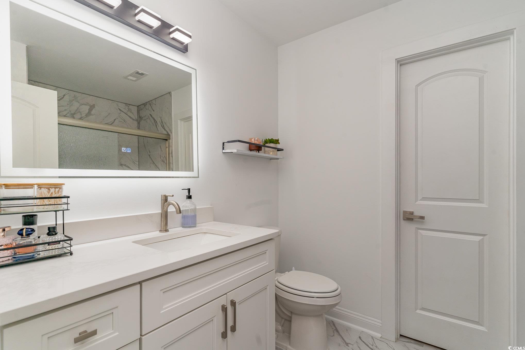 5811 Sumter Drive Myrtle Beach, SC 29577 - Photo 21 of 39 Bathroom featuring vanity, a marble finish shower, and light marble finish flooring