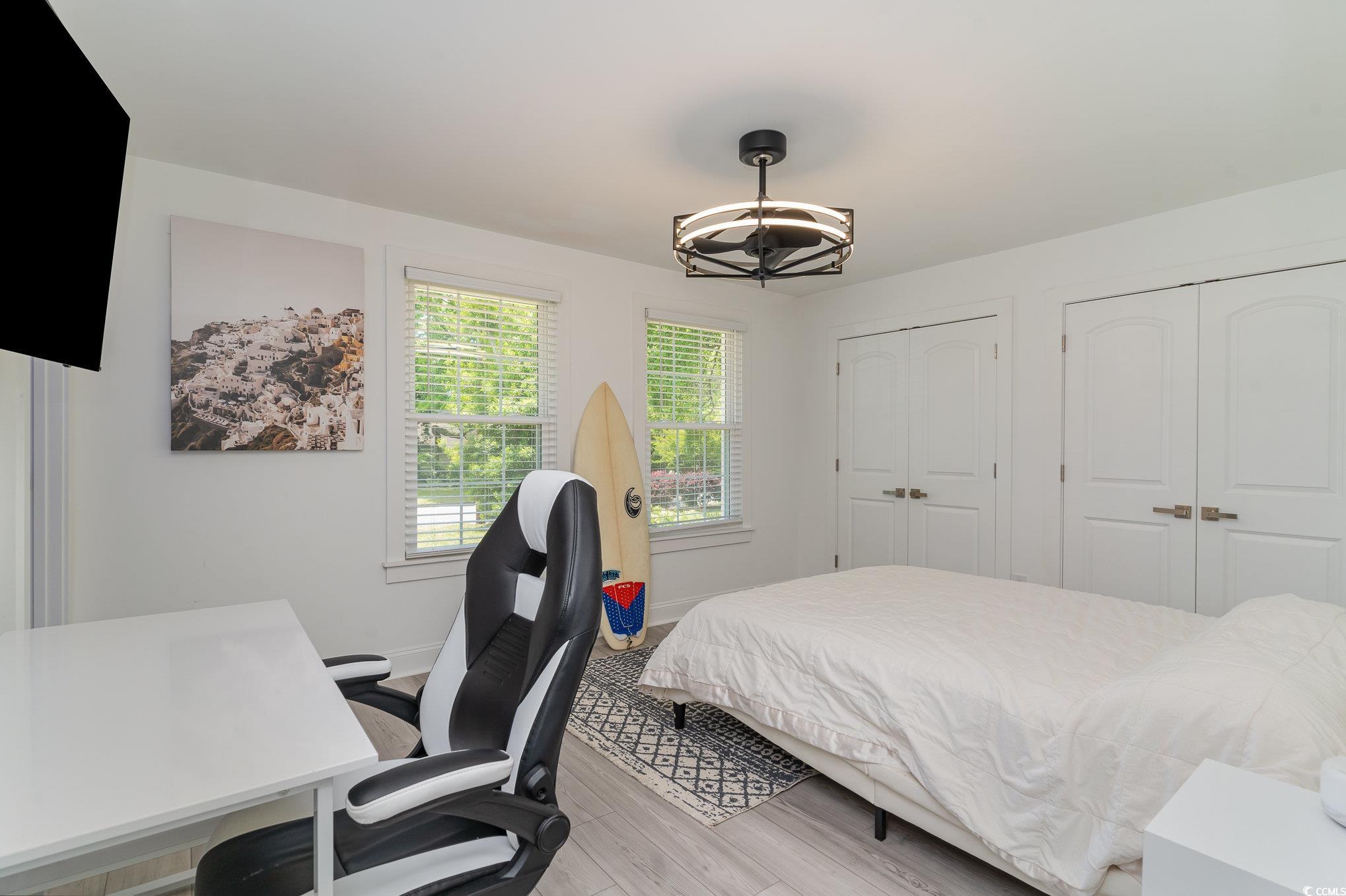 5811 Sumter Drive Myrtle Beach, SC 29577 - Photo 22 of 39 Bedroom featuring wood finished floors, two closets, a chandelier, and an office area