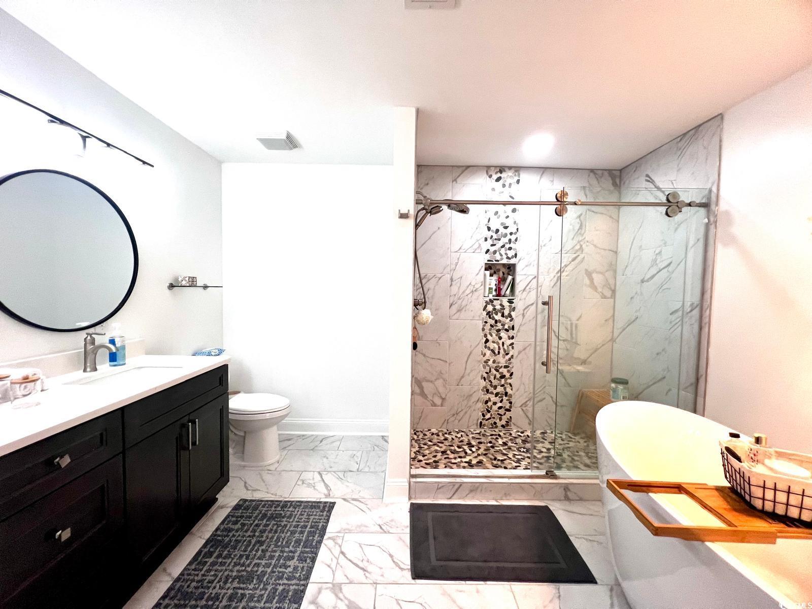5811 Sumter Drive Myrtle Beach, SC 29577 - Photo 28 of 39 Full bath featuring vanity, a freestanding tub, light marble finish floors, and a marble finish shower