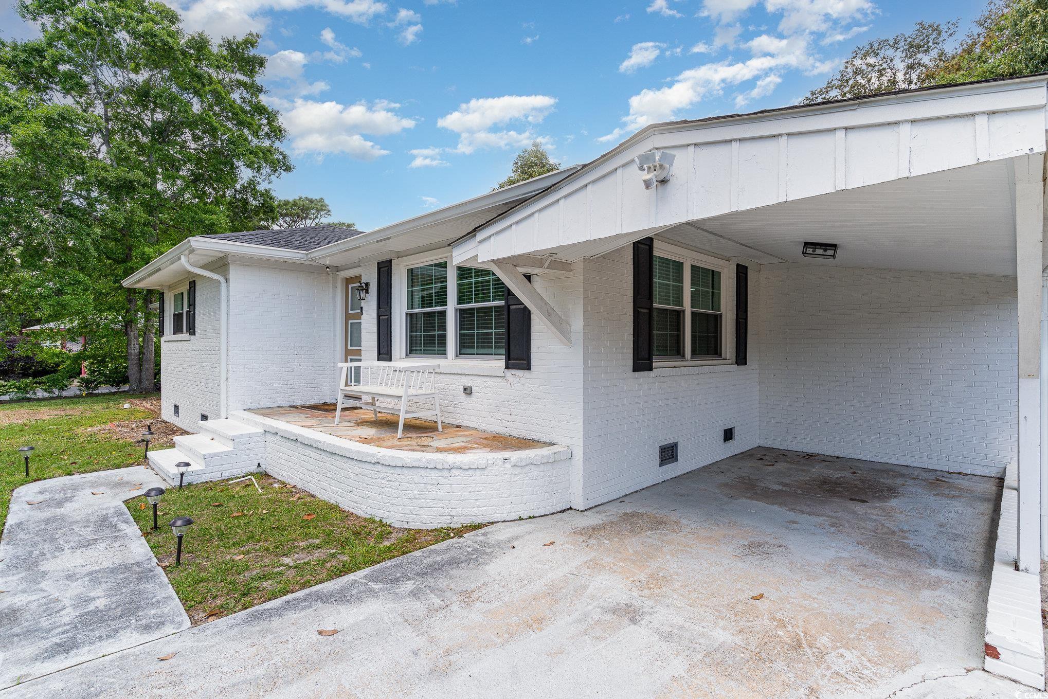 5811 Sumter Drive Myrtle Beach, SC 29577 - Photo 3 of 39 View of front of house featuring crawl space, brick siding, an attached carport, and concrete driveway