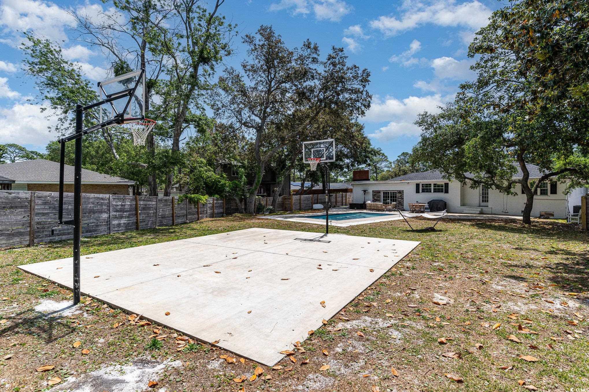 5811 Sumter Drive Myrtle Beach, SC 29577 - Photo 35 of 39 View of sport court with basketball hoop, a fenced backyard, and a patio