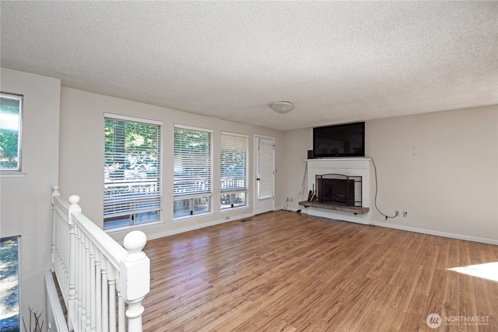 308 Point Fosdick Place Northwest Gig Harbor, WA 98335 - Photo 11 of 35 a view of an empty room with wooden floor and a window