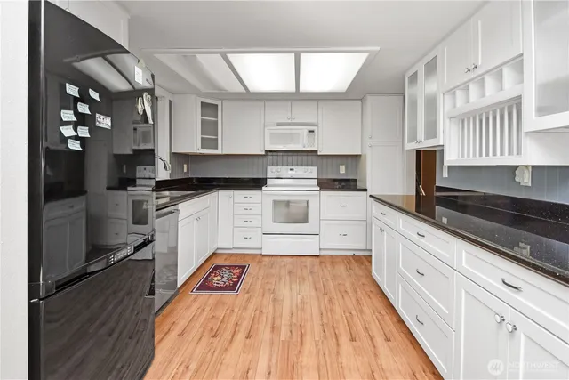 a kitchen with stainless steel appliances granite countertop a stove a sink and a refrigerator