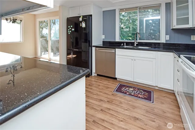 a kitchen with granite countertop a sink a stove and refrigerator