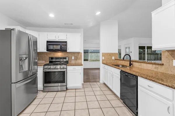 a kitchen with stainless steel appliances a refrigerator sink and microwave