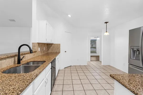 a kitchen with a sink a refrigerator and cabinets