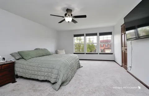 a spacious bedroom with a bed and a flat screen tv