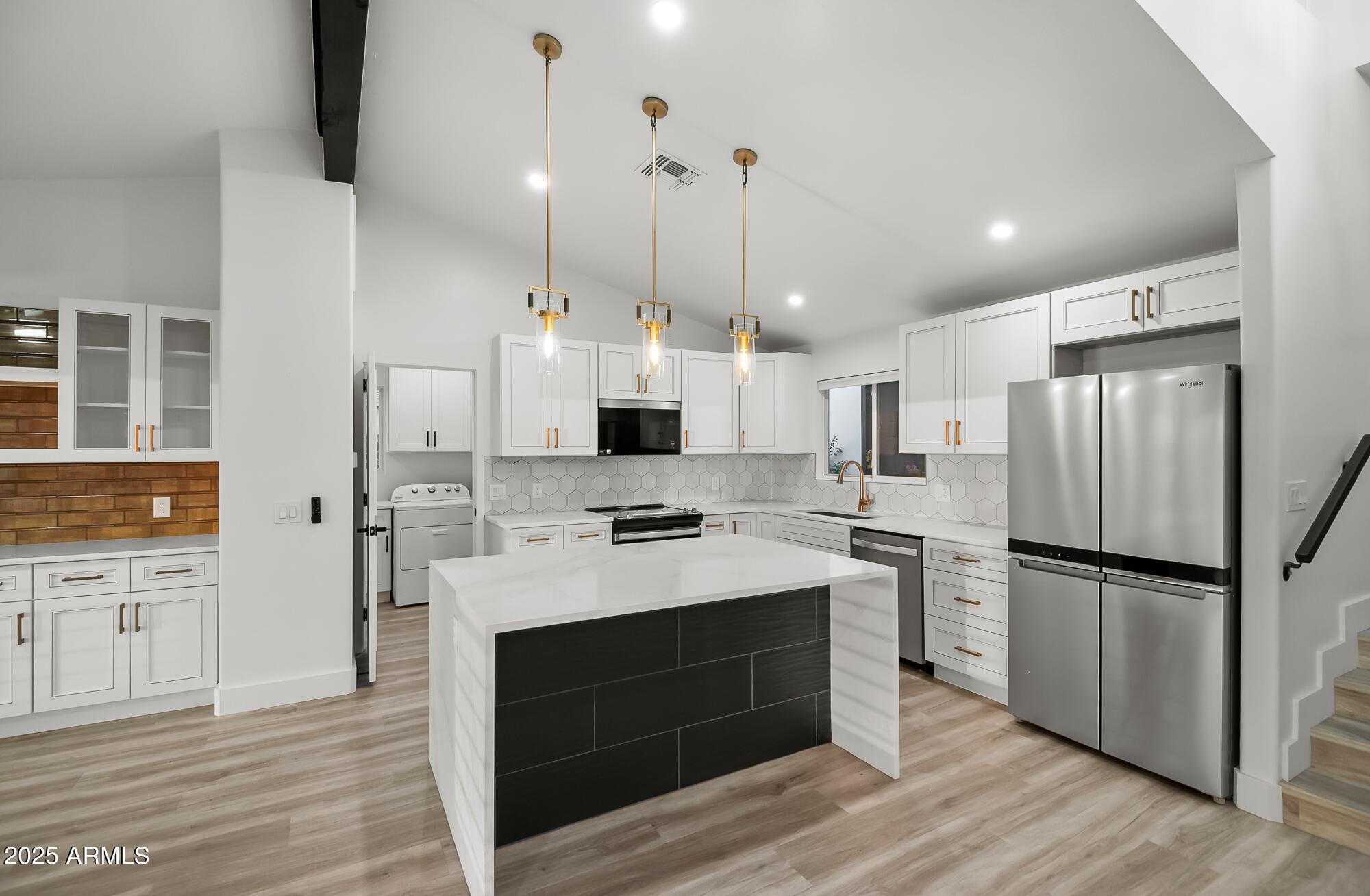 13428 North 16th Place Phoenix, AZ 85022 - Photo 5 of 29 a kitchen with stainless steel appliances a stove a refrigerator and white cabinets with wooden floors