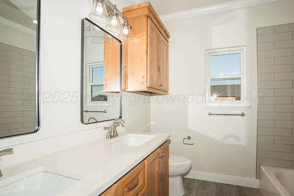 a bathroom with a granite countertop sink a toilet and a mirror