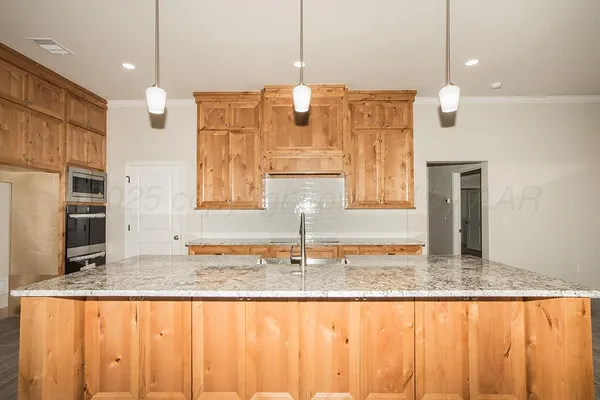 a kitchen with kitchen island granite countertop kitchen island stainless steel appliances a sink and a counter top space