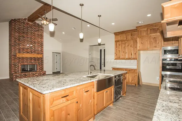 a kitchen with stainless steel appliances granite countertop a sink and a refrigerator