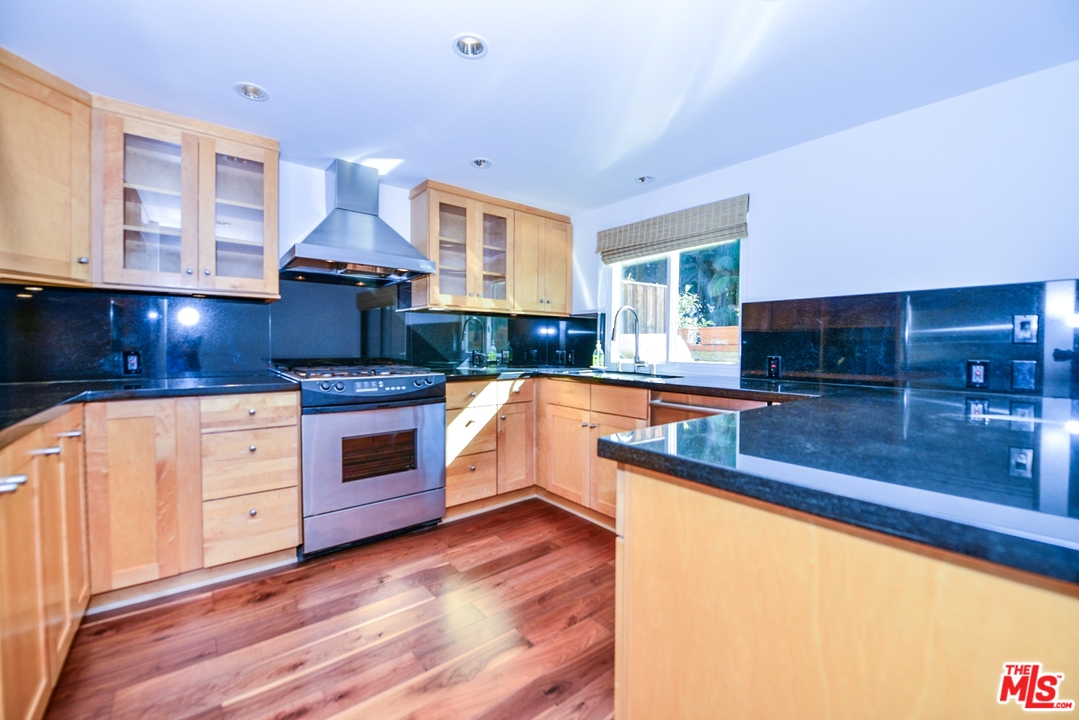 914 2nd Street, Unit B Santa Monica, CA 90403 - Photo 6 of 29 a kitchen with stainless steel appliances granite countertop a sink a stove and a wooden floors