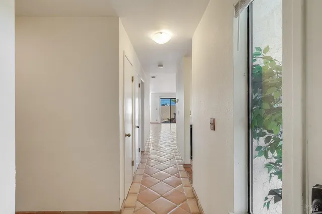 a view of a hallway with wooden floor and a dining room