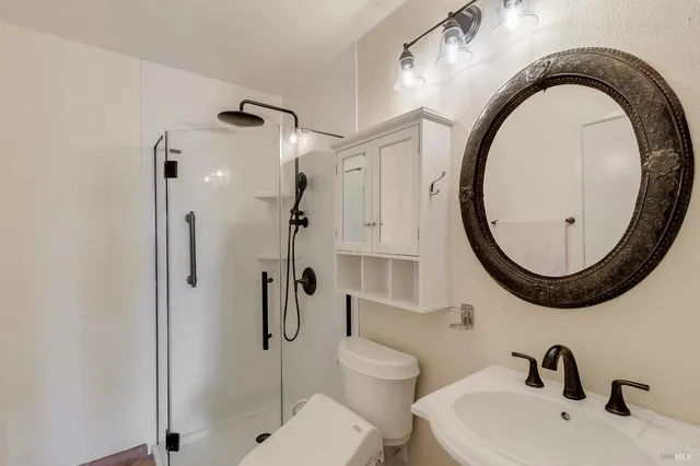 a bathroom with a sink a toilet and a mirror
